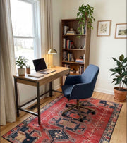 5' x 8' Rectangular Rust Red & Navy Blue Tribal Geometric Southwestern Area Rug styled in a home office with a wooden desk and blue office chair.
