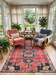 5' x 8' Rectangular Rust Red & Navy Blue Tribal Geometric Southwestern Area Rug styled in a living room with coral and blue accent chairs.