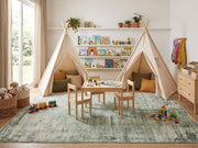 5' x 8' Rectangular Sage Green & Ivory Distressed Floral Ornamental Border Vintage Transitional Area Rug styled in a children's playroom with canvas play tents and a small wooden activity table.
