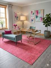 5' x 8' Rectangular Vibrant Pink Tonal Distressed Modern Contemporary Washable Area Rug styled in a home office beneath a gold-framed glass desk with a teal office chair.