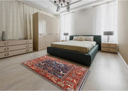 5' x 8' Red and Blue Mid-Century Modern Oriental Area Rug displayed in a bedroom setting showing the bold red border and deep blue center with intricate floral motifs.