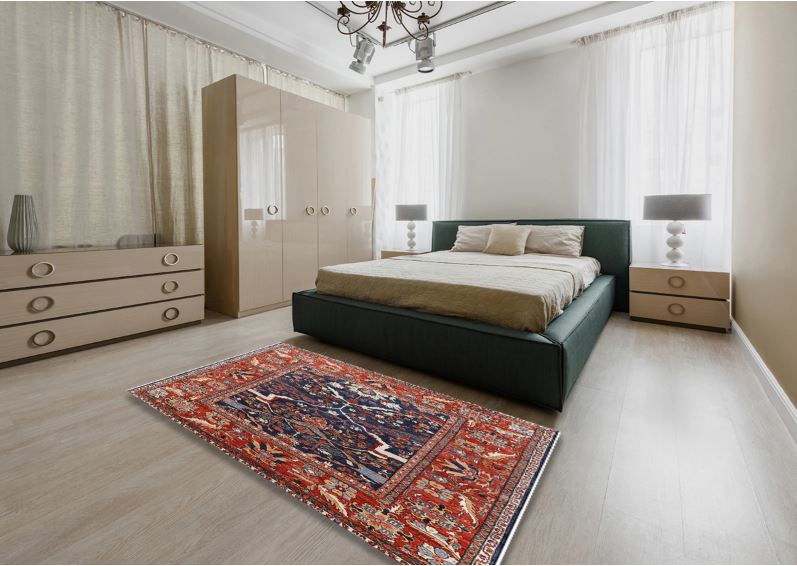 5' x 8' Red and Blue Mid-Century Modern Oriental Area Rug displayed in a bedroom setting showing the bold red border and deep blue center with intricate floral motifs.