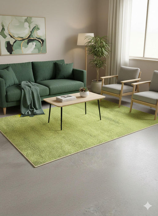 5' x 8' avocado green and cream washable solid plush area rug styled in a contemporary living room with a green sofa, minimalist coffee table, and natural indoor plants.