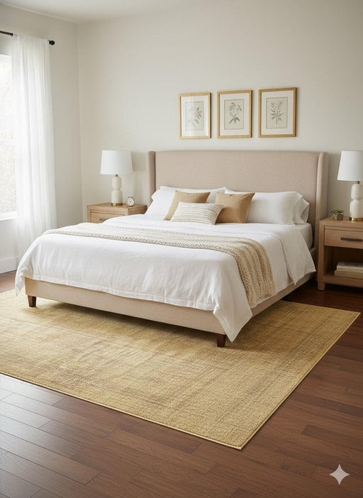5' x 8' natural beige warm sand washable solid textured area rug styled in a bright neutral bedroom with light wood furniture and soft cream bedding.