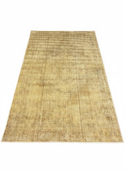 5' x 8' rectangular washable area rug featuring a natural beige and warm sand tone with a subtle solid textured design and lightly distressed finish.