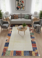 5' x 8' washable patchwork border area rug styled in a cozy living room with a neutral sofa and accent chairs, featuring a colorful patchwork border framing the soft ivory center.