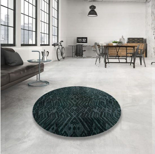 5ft Round Dark Teal Charcoal Abstract Modern Area Rug displayed in a modern loft-style living space, highlighting the deep teal and charcoal tones with bold abstract geometric patterns.