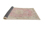 5ft Round Desert Sand Beige Pink Traditional Medallion Area Rug rolled corner view showing the flexible backing and finished edges.