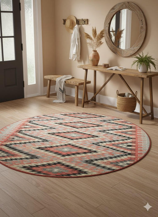 6' Round Rust & Cream Southwestern Geometric Area Rug placed / styled in a modern entryway with a wooden bench, round wall mirror, and potted plant.