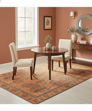 6' x 6' Square Rust Orange Multi Color Tree of Life Botanical Motif Tribal Area Rug styled under a dining table showcasing the square shape and decorative tribal inspired border.