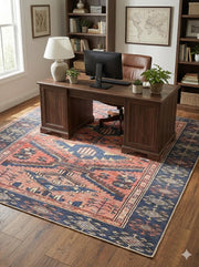 6' x 6' square blue and rust Southwestern tribal washable area rug styled under a wooden desk in a cozy home office with bookshelves and natural light.