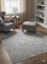 6' x 6' square blue, ivory, and gray tonal damask transitional area rug placed beneath a lounge chair and ottoman in a cozy reading corner.