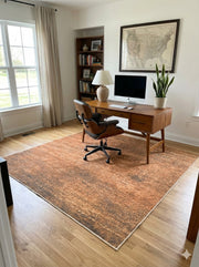 6' x 6' square brown & beige with subtle gray tones distressed modern washable area rug placed in home office under wooden desk.