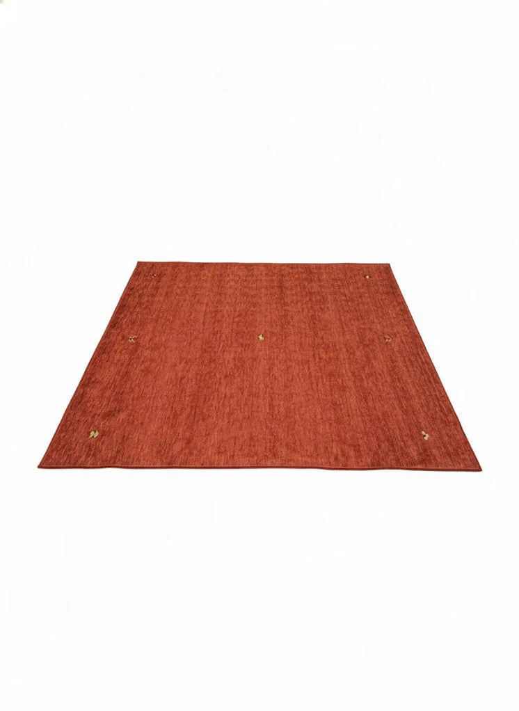 6' x 6' square rust burnt orange solid modern washable area rug featuring subtle textured tones with a non-slip backing.