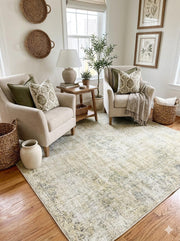 6' x 6' square soft sage and light cream distressed area rug styled in a cozy seating area with neutral armchairs and natural decor.