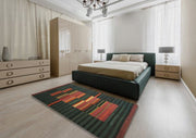 6' x 9' Contemporary Army Green Modern Area Rug styled in a contemporary bedroom setting, highlighting the deep green striped background and colorful central pattern.