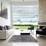 6' x 9' Mid-Century Modern Dark Gray Oriental Area Rug displayed in a bright modern living room, showcasing the minimalist design and versatile gray color palette.