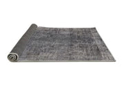 6' x 9' Mid-Century Modern Dark Gray Oriental Area Rug rolled corner perspective revealing the flexible backing and neatly finished edges.