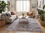 6' x 9' Rectangular Blue Beige Distressed Geometric Tribal Southwestern Area Rug styled in a modern living room with a light gray sofa, wooden coffee table, tan accent chair, and indoor plants.