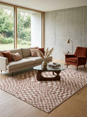 6' x 9' Rectangular Brown Ivory Checkered Geometric Modern Washable Area Rug styled in a living room with a beige sofa, glass coffee table, and rust-colored accent chair.