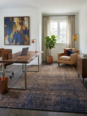 6' x 9' Rectangular Brown Navy Crackled Geometric Modern Area Rug styled in a home office with a wooden desk, laptop, tan leather accent chair, and wooden storage cabinet.