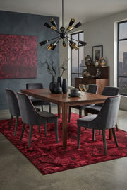 6' x 9' Rectangular Burgundy Red Abstract Geometric Modern Area Rug styled in a dining room with a wooden dining table and gray upholstered chairs.