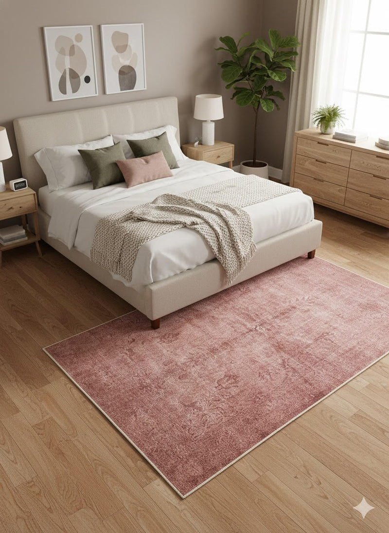 6' x 9' Rectangular Dusty Rose & Soft Brown Distressed Solid Traditional Area Rug styled in a contemporary bedroom under a queen-sized bed.