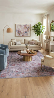 6' x 9' Rectangular Lavender Blue Floral Medallion Traditional Washable Area Rug styled in a living room with a beige sofa and round wooden coffee table.
