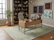 6' x 9' Rectangular Mint Green Distressed Medallion Traditional Washable Area Rug shown beneath a wooden desk in a modern home office with built-in shelving and botanical décor.