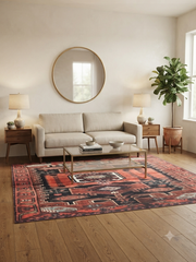 6' x 9' Rectangular Rust Red Black Geometric Medallion Tribal Southwestern Washable Area Rug styled in a living room with a beige sofa and glass coffee table.