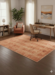 6' x 9' burnt orange and soft brown textured modern rectangular area rug styled beneath a wooden desk in a bright home office.