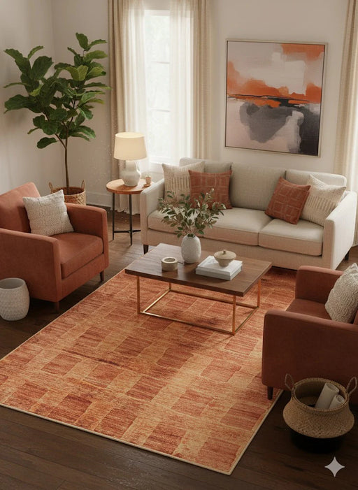 6' x 9' burnt orange and soft brown textured modern rectangular area rug styled in a warm living room with rust accent chairs and neutral sofa.