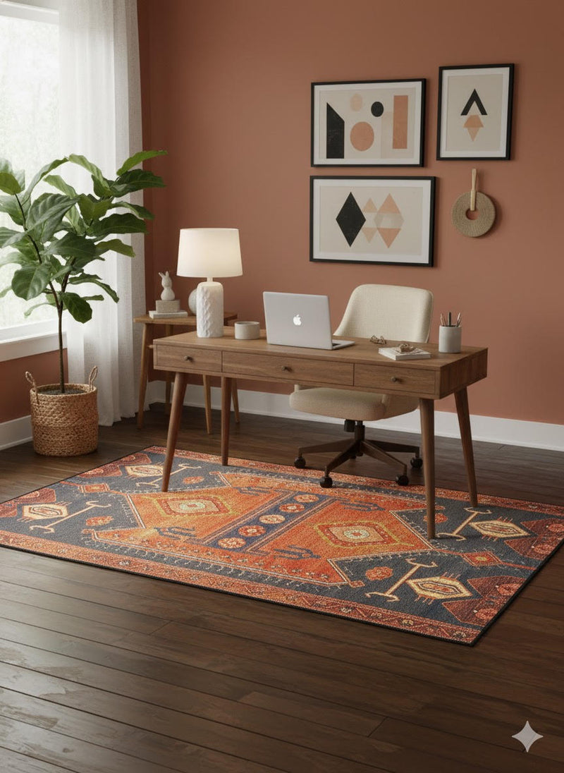 6' x 9' multi-color southwestern geometric rectangular area rug placed under a wooden desk in a modern home office with warm terracotta walls.