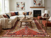6' x 9' multi-color tribal medallion traditional area rug styled beneath a wooden coffee table in a warm living room with rust and navy accents.
