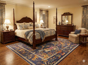 6' x 9' navy blue multi-color hunting scene area rug positioned beneath a four-poster bed in a traditional bedroom setting.