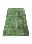 6' x 9' rectangular area rug in solid grass green featuring subtle cream variations and a lightly distressed textured finish.