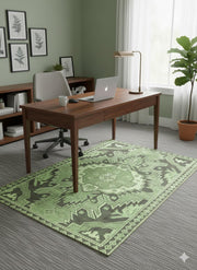 6' x 9' sage and olive green geometric washable area rug styled in a modern home office under a wooden desk with botanical wall art and natural decor.