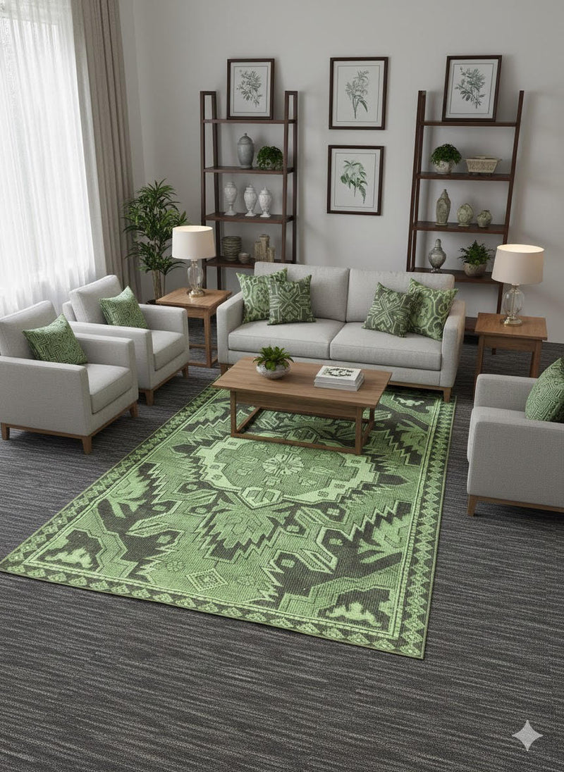 6' x 9' sage and olive green geometric washable area rug with tribal-style motifs placed in a neutral living room with light sofas and wood accents.