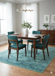 6' x 9' teal soft blue mint green floral vintage rectangular area rug styled beneath a wooden dining table with upholstered teal chairs in a bright dining room.