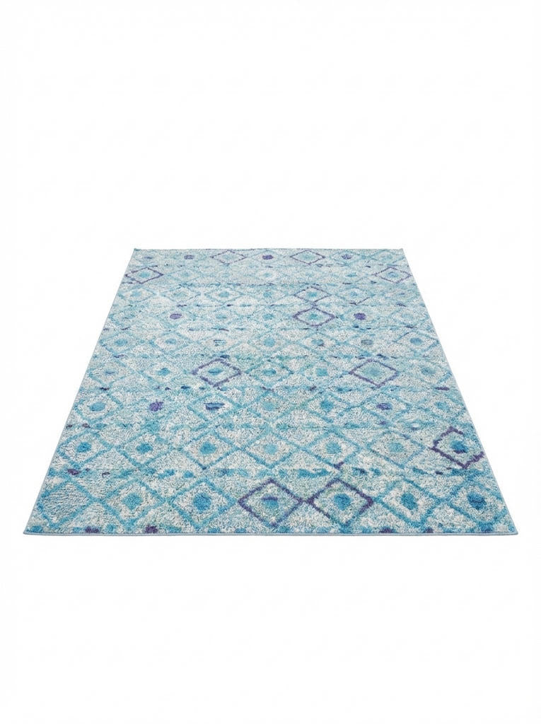 6' x 9' washable area rug featuring a teal blue background with soft geometric diamond patterns and light purple accents in a modern textured design.