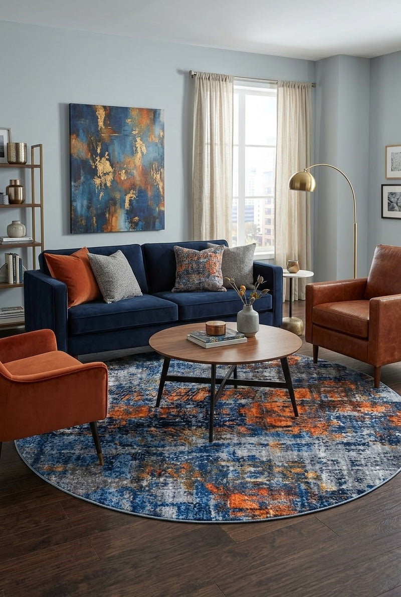 7' Round Navy Blue Orange Gray Distressed Abstract Modern Area Rug styled in a living room with a navy blue sofa and round wooden coffee table.