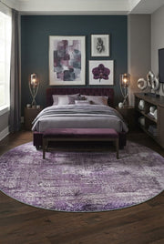 7' Round Purple Lavender Gray Distressed Abstract Modern Area Rug placed in a bedroom with a purple upholstered bed and matching bench.