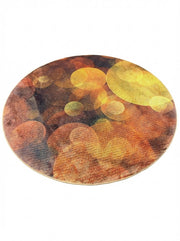 7 ft round modern area rug featuring an abstract multi-color pattern with warm tones of orange, gold, brown, and charcoal.