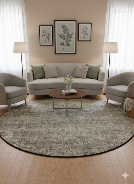 7' round beige, ivory, taupe, and gray heathered washable area rug styled in a neutral living room with a curved sofa, accent chairs, and light wood decor.