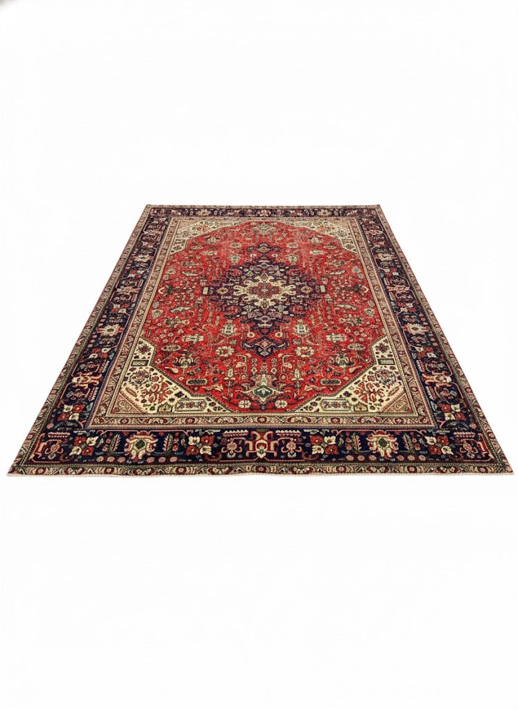 7' x 10' rectangular area rug featuring a red center medallion with navy and cream traditional Persian-style floral motifs and a detailed border.