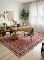 7' x 10' red, beige, and soft brown floral medallion traditional area rug styled beneath a wooden desk in a warm, plant-filled home office.