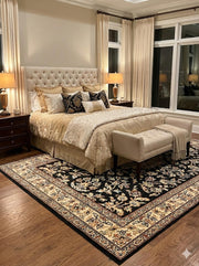 7' x 7' Square Black & Ivory Beige Floral Medallion Traditional Area Rug styled in an elegant bedroom with tufted headboard and wood nightstands.