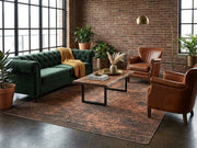 7' x 7' Square Dark Brown & Rust Distressed Abstract Modern Washable Area Rug styled in an industrial living room with a green velvet sofa, brown leather armchairs, and wooden coffee table.
