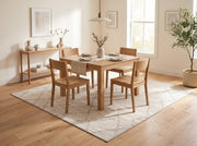 7' x 7' Square Ivory & Gray Diamond Geometric Moroccan Modern Washable Area Rug styled in a dining room beneath a wooden dining table and matching chairs.