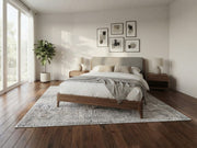 7' x 7' Square Ivory & Light Gray Distressed Textured Modern Washable Area Rug placed in a modern bedroom beneath a wooden bed with white bedding and gray accents.